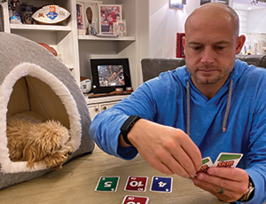 PJ Fleck playing cards with his dog by his side